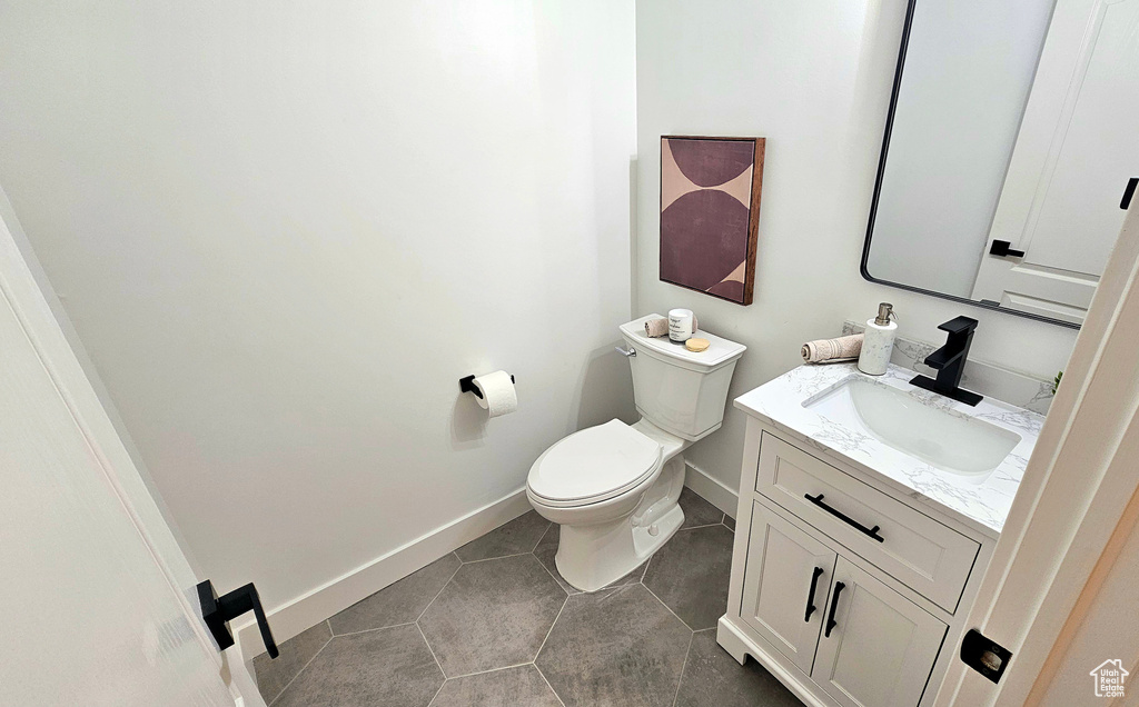 Bathroom featuring tile patterned flooring, vanity, and toilet