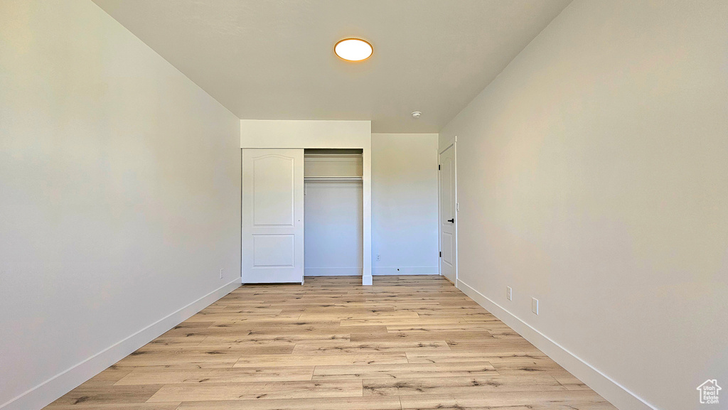 Unfurnished bedroom with light wood-type flooring and a closet