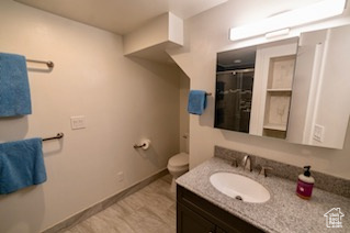 Bathroom featuring vanity, toilet, and walk in shower