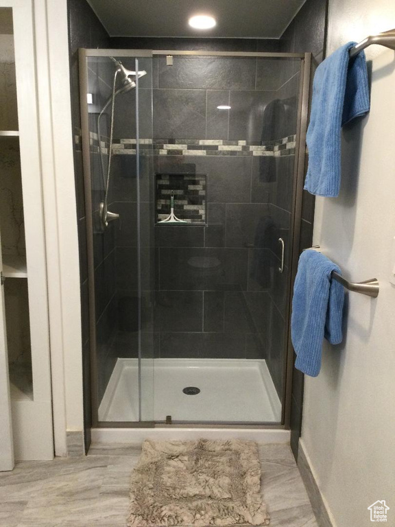 Bathroom with wood-type flooring and a shower with shower door