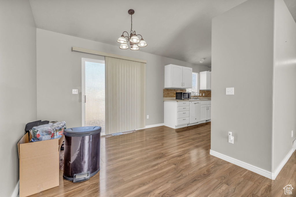 Dining space featuring an inviting chandelier, light hardwood / wood-style flooring, and sink