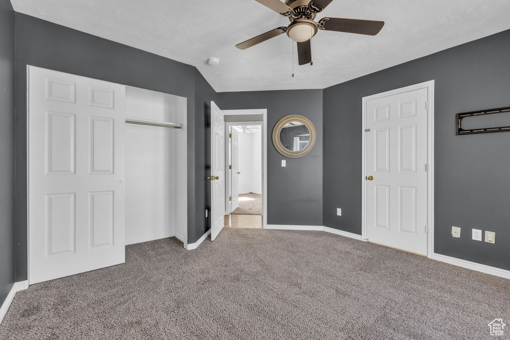 Unfurnished bedroom with lofted ceiling, light carpet, and ceiling fan