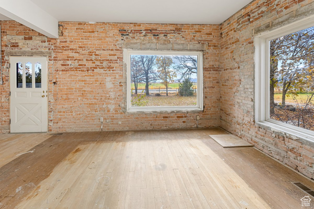 Unfurnished dining area featuring plenty of natural light and brick wall