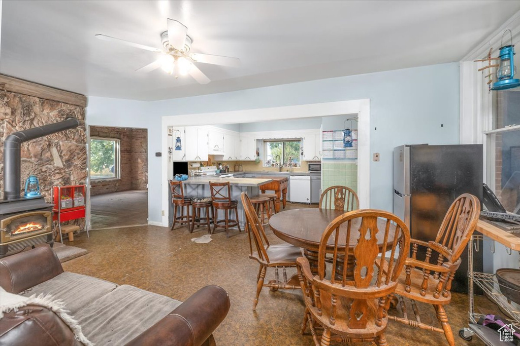 Dining room featuring ceiling fan and a wood stove