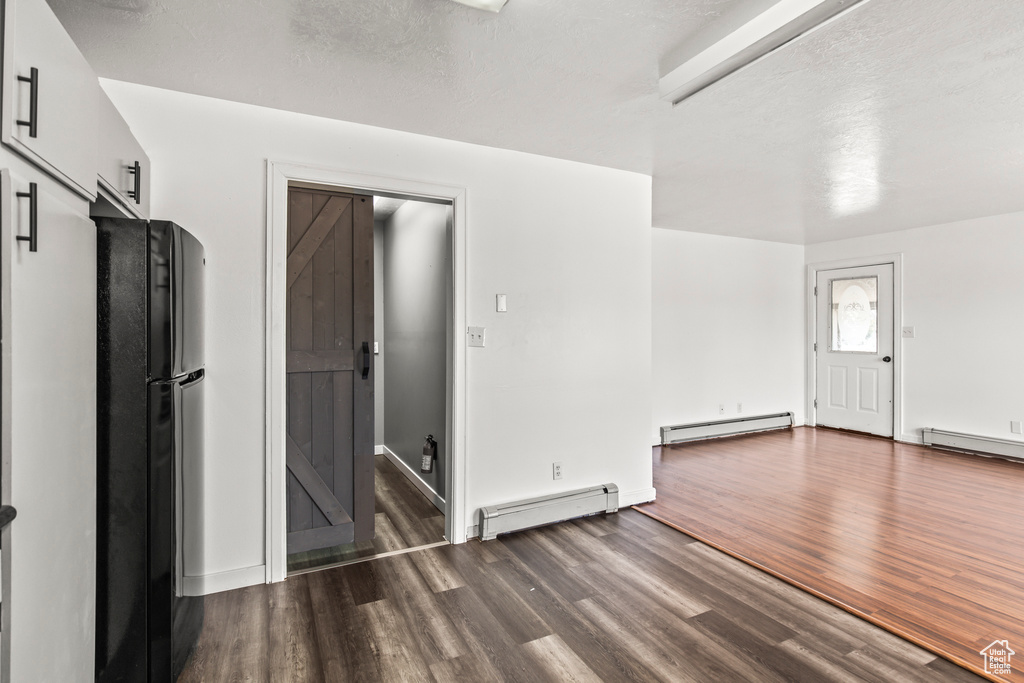 Interior space featuring hardwood / wood-style floors and a baseboard heating unit