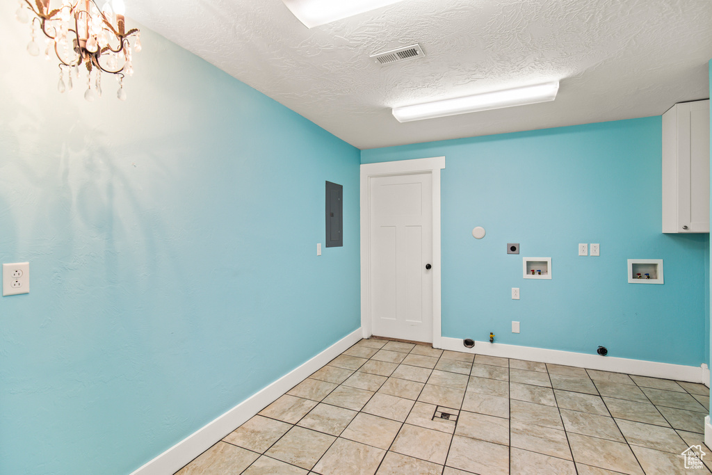 Laundry area with hookup for a washing machine, a textured ceiling, hookup for a gas dryer, an inviting chandelier, and electric dryer hookup