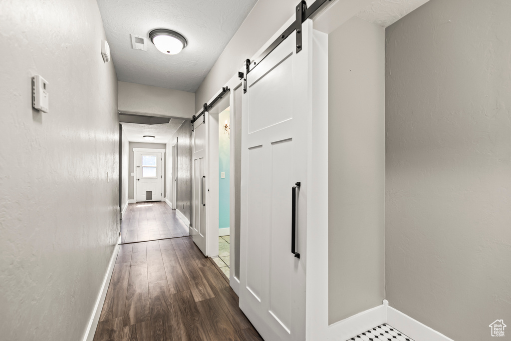 Corridor featuring dark hardwood / wood-style floors and a barn door