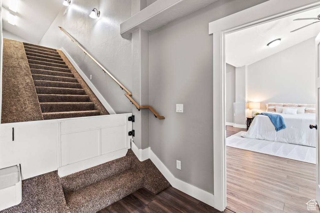 Stairs with wood-type flooring and ceiling fan