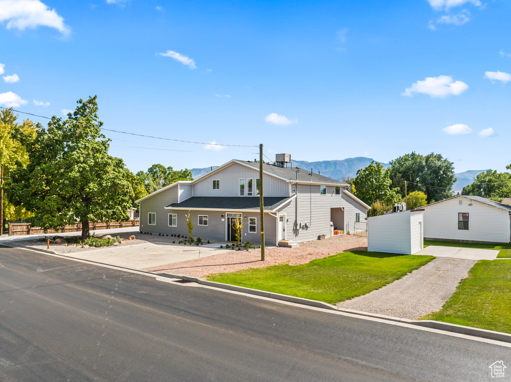 View of front of property featuring a front yard and a mountain view