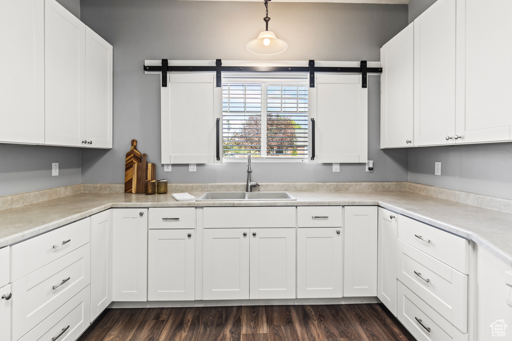 Kitchen with a barn door, sink, and white cabinets