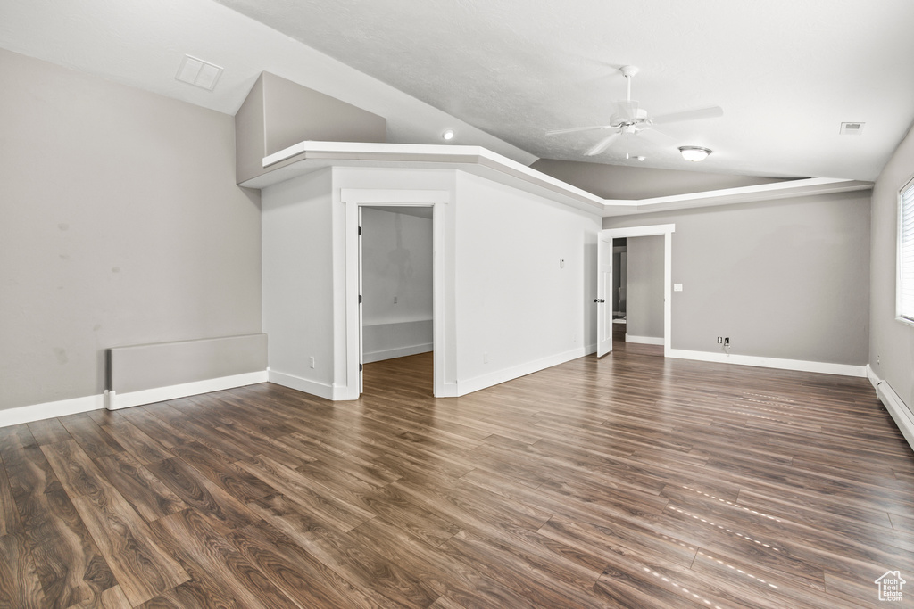 Unfurnished living room with vaulted ceiling, ceiling fan, and dark hardwood / wood-style flooring