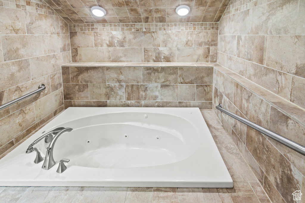 Bathroom with tile walls and tiled tub