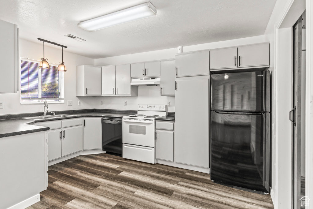 Kitchen with hanging light fixtures, fridge, dark hardwood / wood-style floors, black dishwasher, and white electric stove