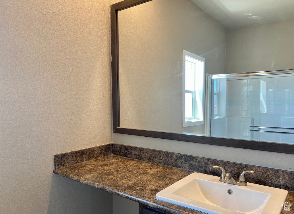 Bathroom with a shower with door and sink