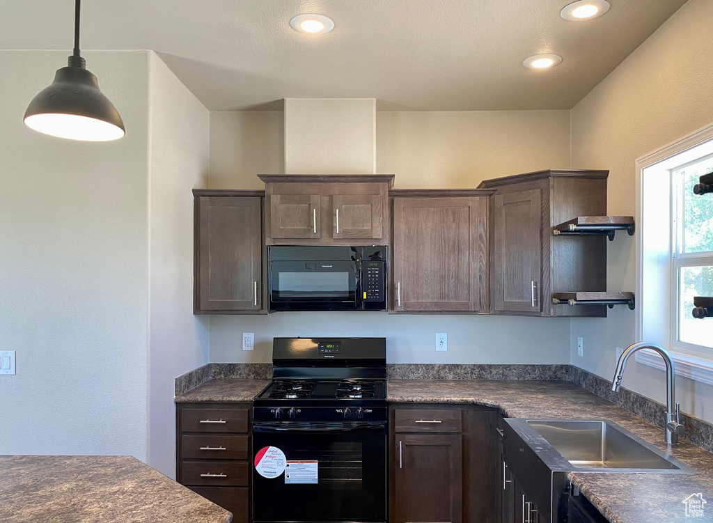 Kitchen featuring black appliances, dark brown cabinetry, and sink