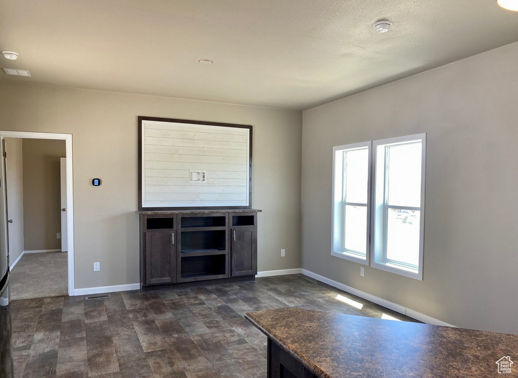 Unfurnished living room with dark wood-type flooring