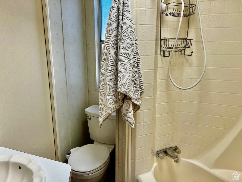 Bathroom with shower / bath combination with curtain and toilet