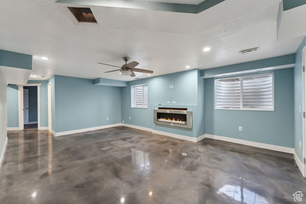 Unfurnished living room featuring ceiling fan