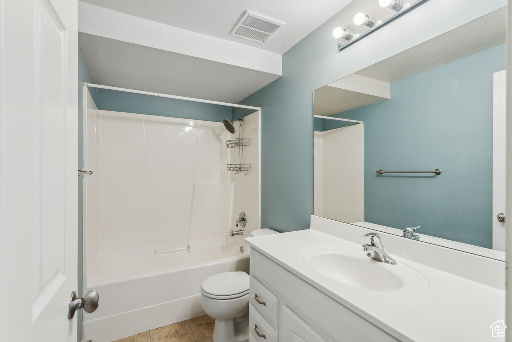 Full bathroom featuring vanity, bathtub / shower combination, toilet, and tile patterned floors