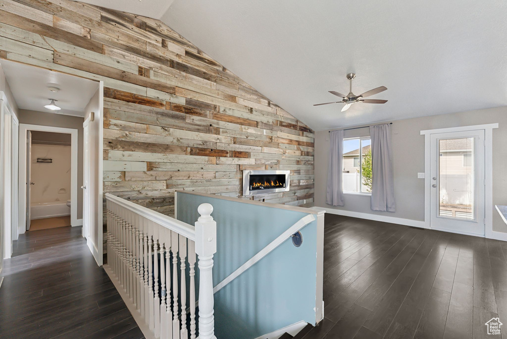 Interior space featuring wood walls, vaulted ceiling, and dark hardwood / wood-style flooring