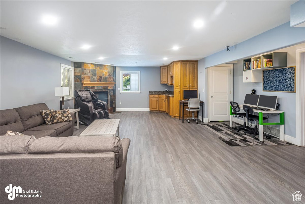 Living room featuring a stone fireplace and hardwood / wood-style floors