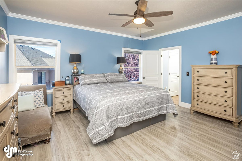 Bedroom featuring ceiling fan, light wood-type flooring, and crown molding