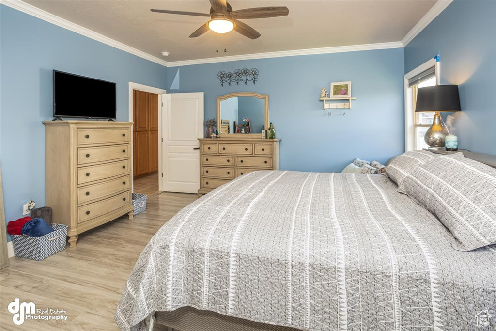 Bedroom with light wood-type flooring, crown molding, and ceiling fan