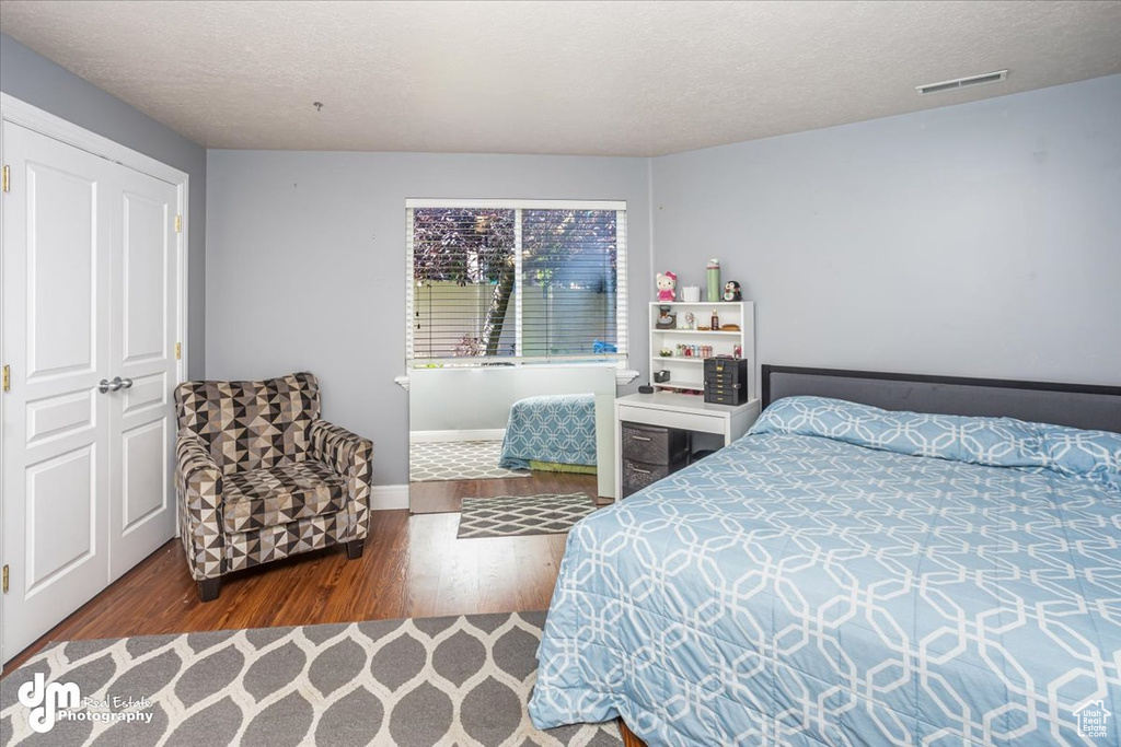 Bedroom featuring a textured ceiling and hardwood / wood-style floors