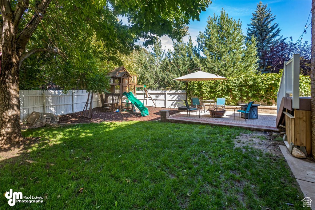 View of yard with a playground and a patio