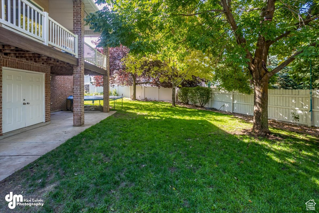 View of yard with a patio and a trampoline