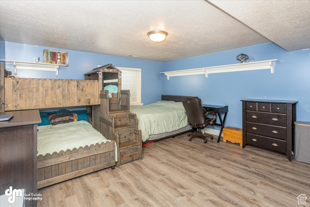 Bedroom with a textured ceiling and light wood-type flooring