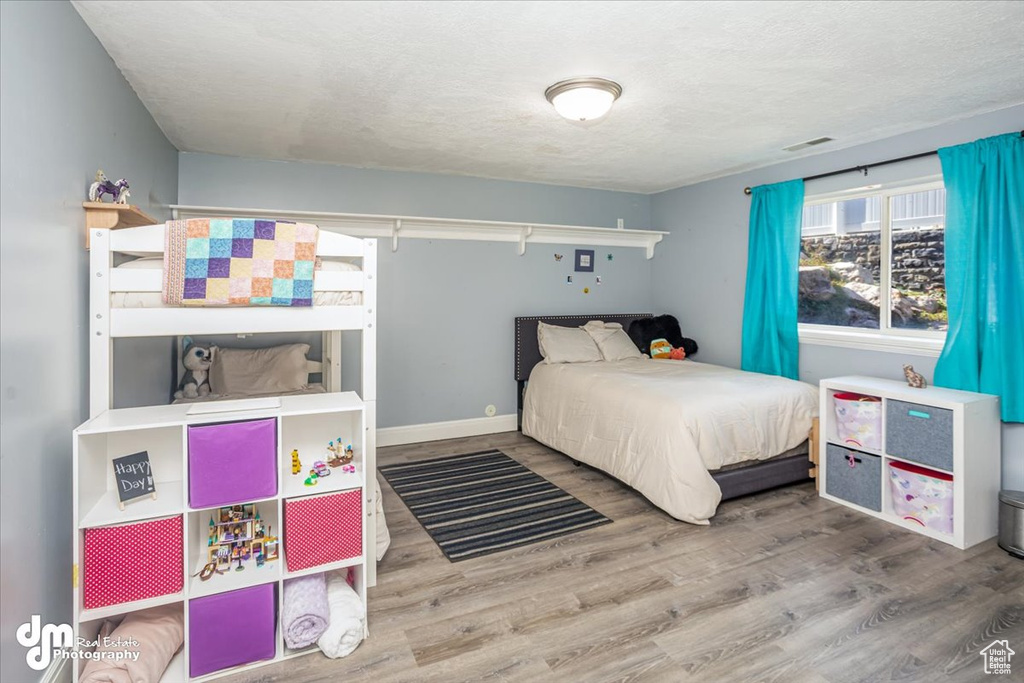 Bedroom featuring a textured ceiling and wood-type flooring