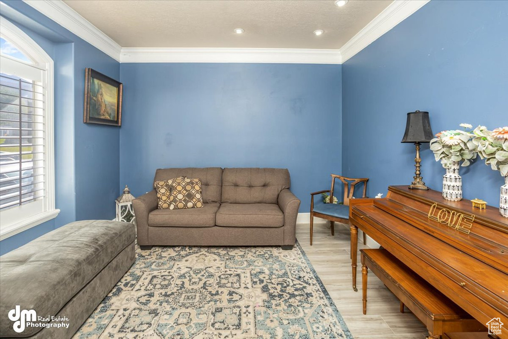 Living room featuring ornamental molding and light hardwood / wood-style floors