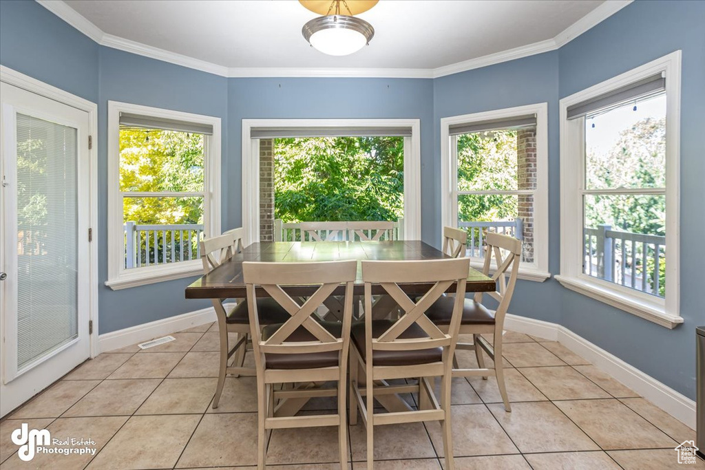 Tiled dining area featuring crown molding