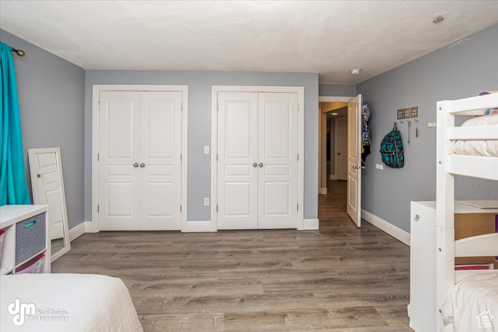 Bedroom with hardwood / wood-style flooring and two closets