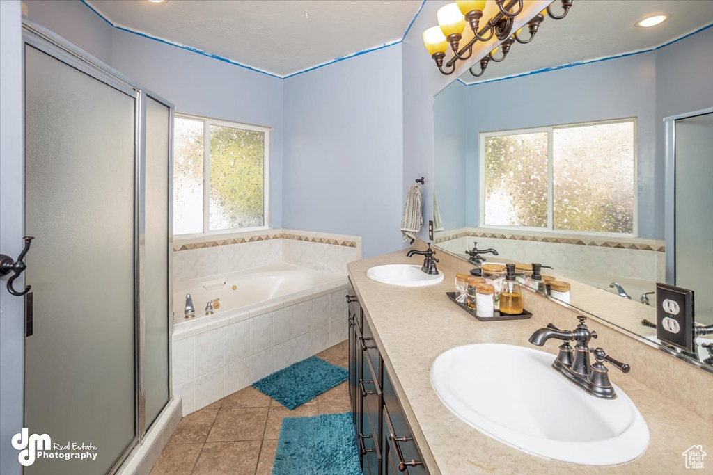 Bathroom featuring plus walk in shower, tile patterned flooring, and vanity