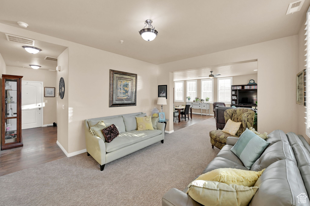 Living room featuring wood-type flooring and ceiling fan