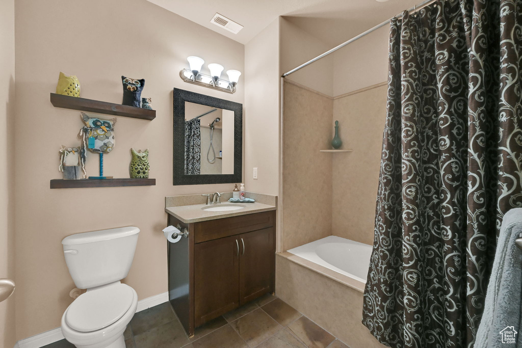 Full bathroom featuring shower / bath combination with curtain, vanity, toilet, and tile patterned floors