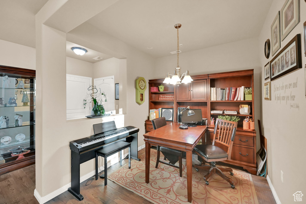 Office space featuring a notable chandelier and hardwood / wood-style floors