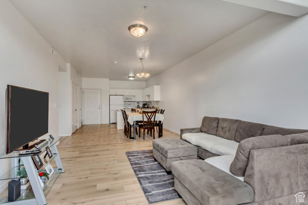 Living room with a chandelier and light hardwood / wood-style floors