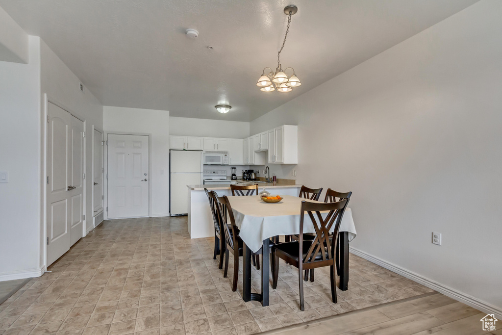 Dining area featuring an inviting chandelier, light hardwood / wood-style floors, and sink