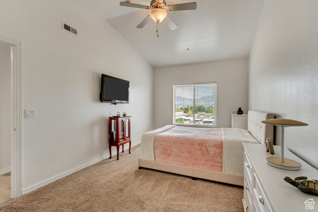 Carpeted bedroom with ceiling fan and vaulted ceiling