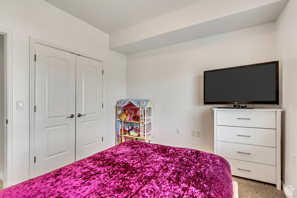 Carpeted bedroom featuring a closet
