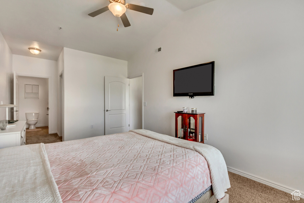 Bedroom with connected bathroom, lofted ceiling, ceiling fan, and carpet flooring