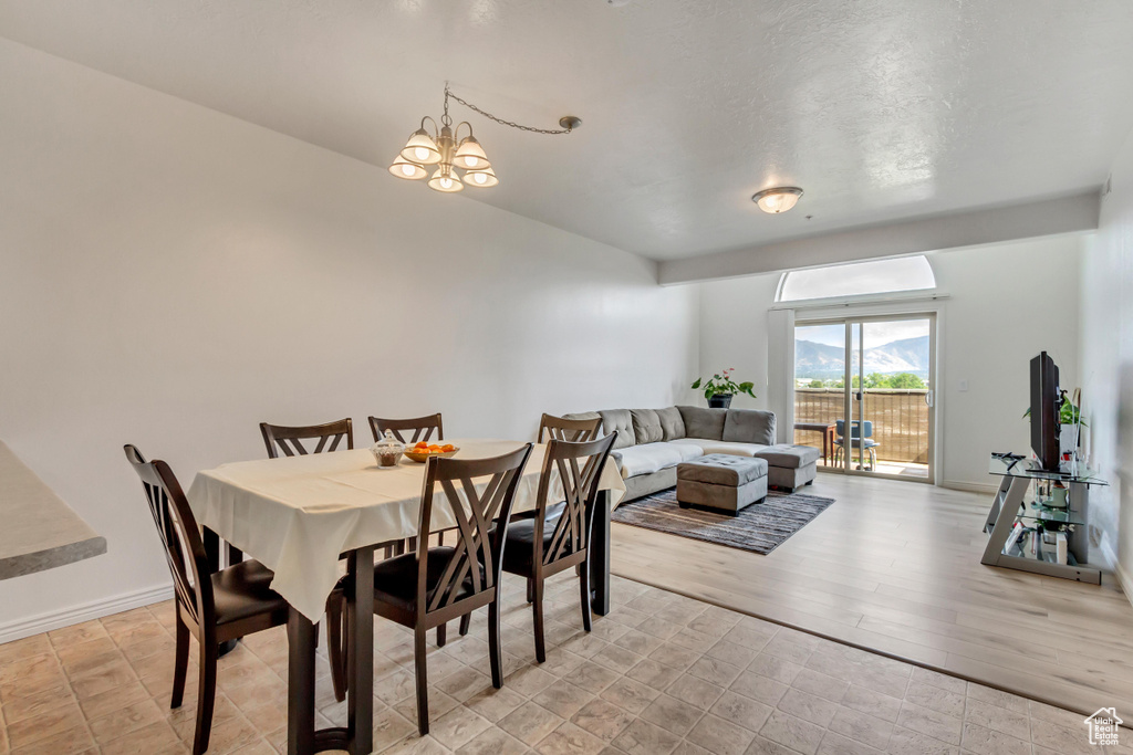 Dining space with light hardwood / wood-style flooring and a notable chandelier