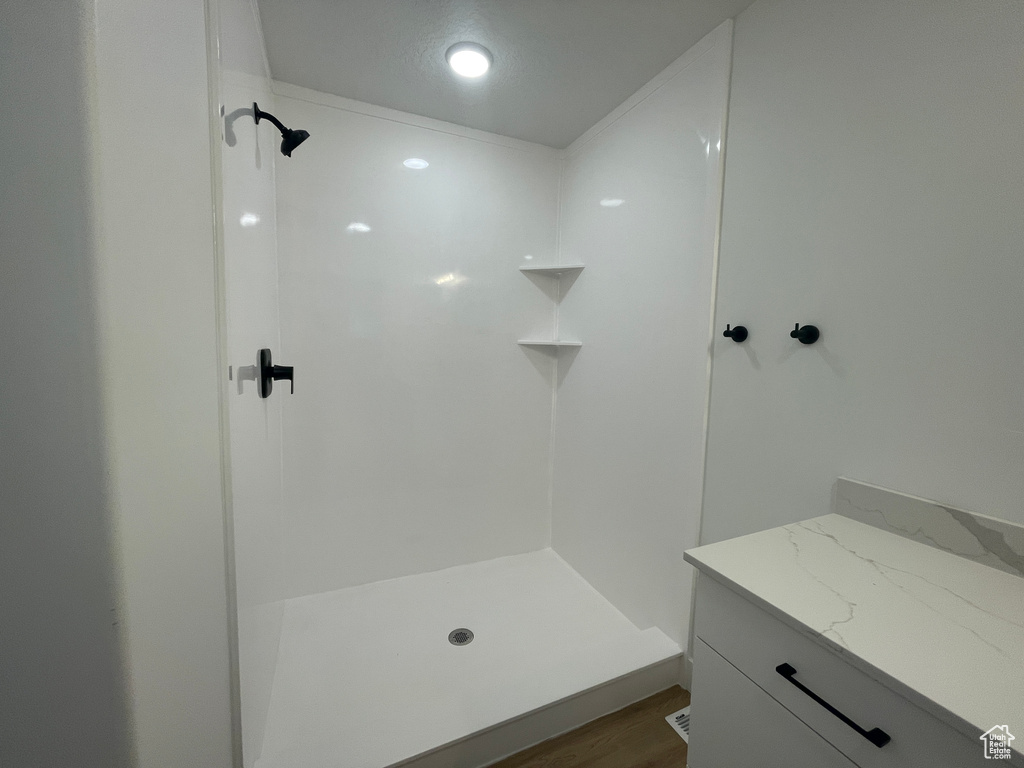 Bathroom with hardwood / wood-style floors and a shower