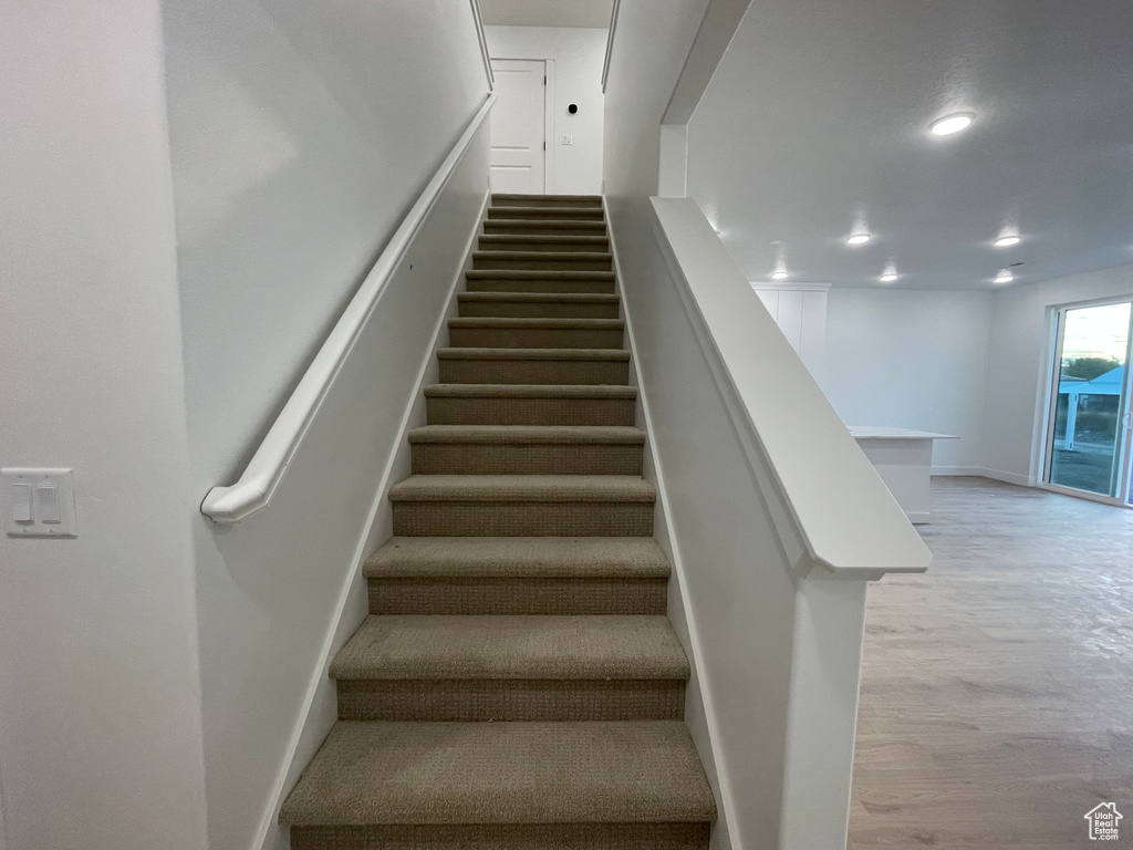 Stairway featuring hardwood / wood-style flooring