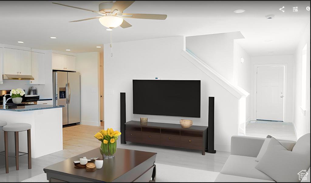 Living room featuring ceiling fan and light hardwood / wood-style flooring