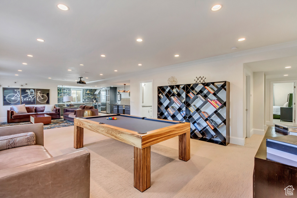 Rec room with pool table, crown molding, ceiling fan, and light colored carpet