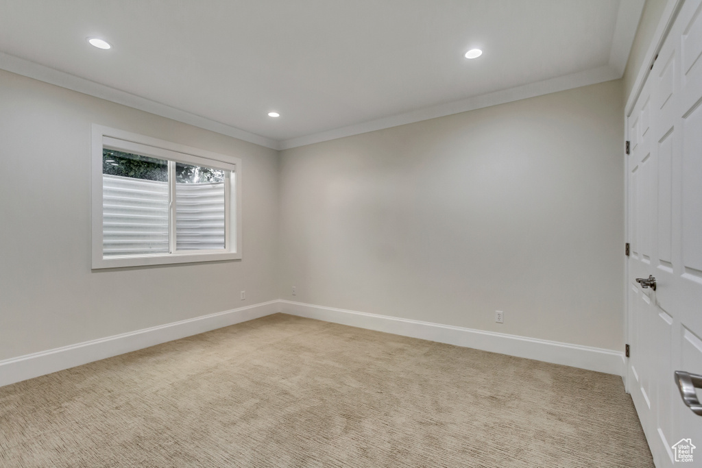 Carpeted spare room with crown molding